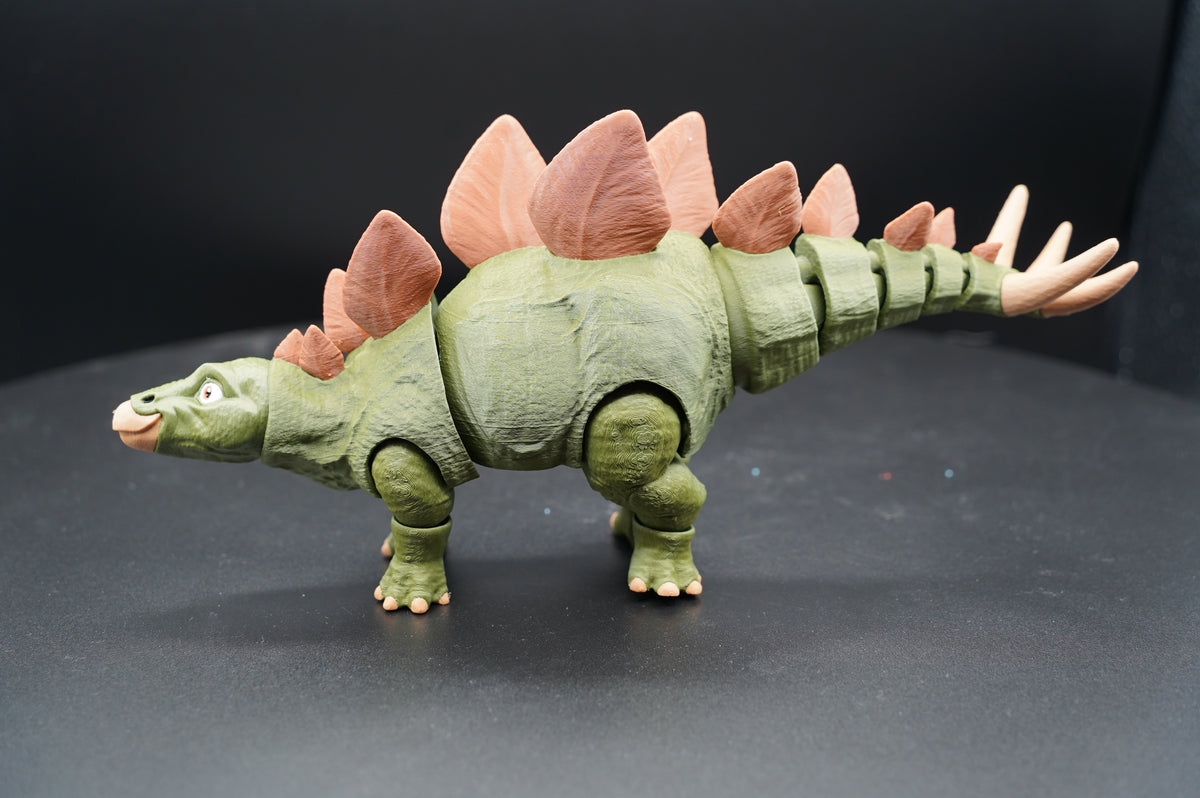 Articulated 3D printed Stegosaurus figurine - front three-quarter view showing expressive face and dorsal plates